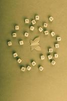 Wooden letter cubes around paper butterfly photo