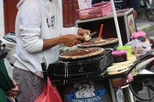 los vendedores de comida que hacen famosa la comida malaya indonesia se llaman leker, leker es una comida para llevar que es popular entre los malayos de indonesia. proceso de fabricación foto