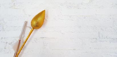 Golden lotus or water lily with incense and gold foil paper for worshiping Buddha isolate on white wall background at  Thai temple. Religious beliefs of Buddhists or Asian people photo