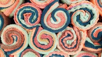 vista superior de toallas de colores o toallas de mano para el fondo. patrón texturizado de pared de algodón o tela. papel tapiz de color artístico y forma del objeto. foto