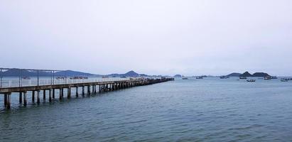 Long bridge among sea or ocean with many boat and white sky background at port Phuket, Thailand. Seascape view with mountain and Natural with photo