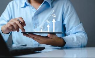 Interest rate and dividend concept. Tablet with percentage symbol and up arrow, Interest rates continue to increase, return on stocks and mutual funds, long term investment for retirement. photo