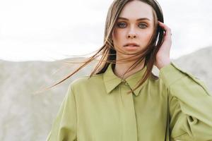 Fashion beauty portrait of young woman with long hair in green organic  shirt on desert background photo