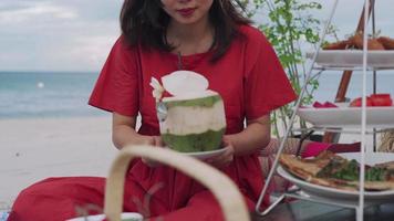Picnic basket with food and coconut juice on the beach. Clear skies and white sandy beaches with the sound of waves and sea view. Concept relax and travel Samui province. video