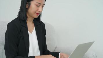 las mujeres de negocios trabajan con computadoras para planificar la producción de bienes. la gente de negocios mira documentos e información. mujer asiática sonríe durante el trabajo. video