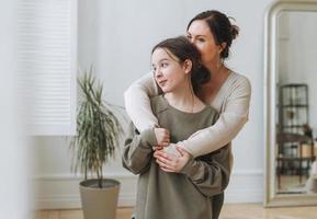 Portrait of mother middle age woman and daughter teenager together in thelight interior photo