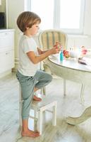 Cute toddler boy child eating egg on kitchen at home on the spring sunny day, Happy Easter photo