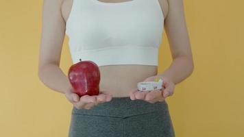 las mujeres de cuerpo delgado eligen durante los alimentos saludables y la comida chatarra, las mujeres eligen manzana para la dieta. buena comida saludable. bajar de peso, equilibrar, controlar, reducir grasa, bajar calorías, rutinas, hacer ejercicio. video