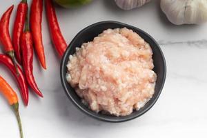 Ground raw chicken in a cooking cup photo