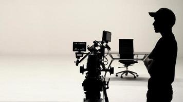 Behind the scenes or making of film in the studio and silhouette of camera man. photo