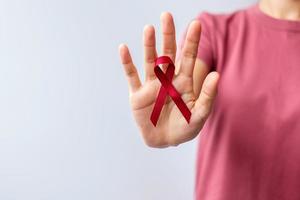 cinta roja burdeos para el cáncer de mieloma múltiple de marzo y el mes de concientización sobre el día mundial del sida de diciembre. concepto de salud y día mundial del cáncer foto