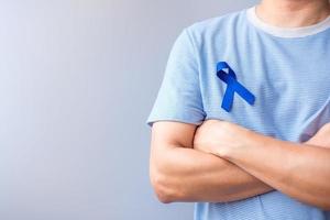 marzo mes de concientización sobre el cáncer colorrectal, mujer sosteniendo una cinta azul oscuro para apoyar a las personas que viven y están enfermas. concepto de salud, esperanza y día mundial contra el cáncer foto