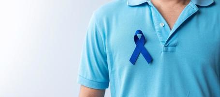 marzo mes de concientización sobre el cáncer colorrectal, mujer sosteniendo una cinta azul oscuro para apoyar a las personas que viven y están enfermas. concepto de salud, esperanza y día mundial contra el cáncer foto