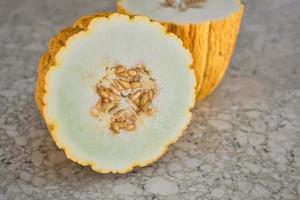 Turkish local yellow melon cut in half on a stone table, close-up, selective fox. the idea of advertising organic fruits from the farmer's market. photo