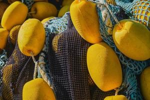 Background of colorful fishing nets with yellow floats, close-up, selective focus. Background for the concept of traditional fishing in coastal towns photo