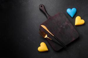 Chocolate hearts in the colors of the Ukrainian flag on a black ceramic plate photo