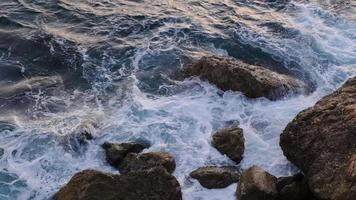 hav vågor brytning på stenar på de kustlinje, natur antal fot 4k. video