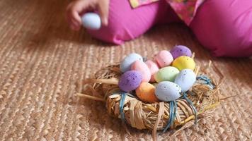 mano del bambino che tiene una ciotola di uova di Pasqua sul rosa video