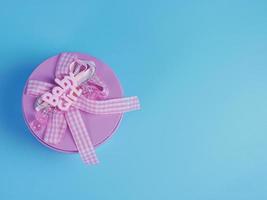 pink gift tin for baby girl isolated on blue background photo