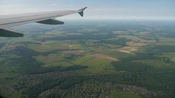 vista aérea al ala de un avión y nubes cúmulos sobre la región de moscú, video de material de archivo. la vista desde el avión a los asentamientos y la carretera sobre la región de moscú