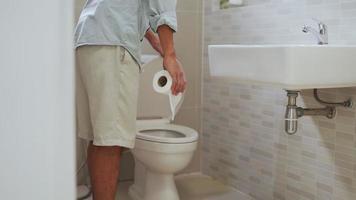 ein mann, der seinen bauch mit bauchschmerzen spürt und mit der hand den toilettendeckel öffnet. Männer haben morgens nach dem Aufwachen Durchfall. Gesundheitskonzepte für Durchfall und Gastritis. video