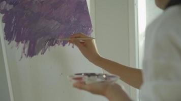 Professionelle Künstler verwenden Farbe für abstrakte Kunst und schaffen Meisterwerke. maler malen mit wasserfarben oder öl im atelierhaus. Frau malt gerne als Hobby. Arbeit, Erholung, Entspannung, Job. video