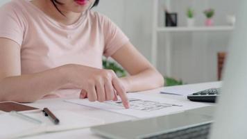 la femme examine la facture de la dette et utilise un téléphone portable pour numériser la facture. les femmes travaillent à domicile et dépensent en ligne pour réduire leur risque de maladies transmissibles. concept de distance sociale en ligne. video