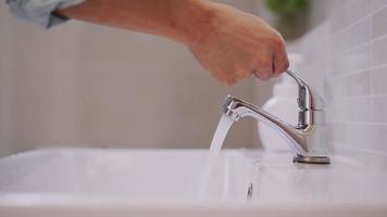 Mann drückt Seifenflasche und Seifenblasen auf seine Hand, um sich auf die Reinigung der Hände vorzubereiten. Männchen waschen ihre Hände mit Seife, um Keime abzutöten. das konzept der sauberkeit für eine gute gesundheit und zum schutz von viren. video