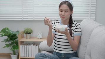 Beautiful girl enjoy eat yogurt on breakfast health in house. Happy young woman smile on morning for good emotion. female Clean eat, dieting, detox, yogurt diet. Diet Happy and Healthy food concept video