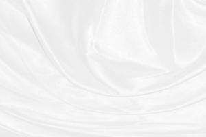 la seda blanca elegante y suave o la textura de tela satinada de lujo se pueden utilizar como fondo de boda. diseño de fondo lujoso foto