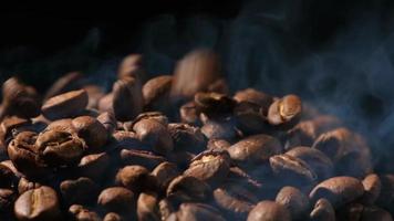 slow motion van gebrande koffiebonen vallen. biologische koffie zaden. video