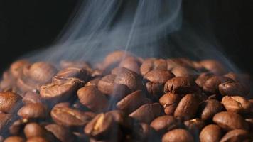 Slow motion of roasted coffee beans falling. Organic coffee seeds.