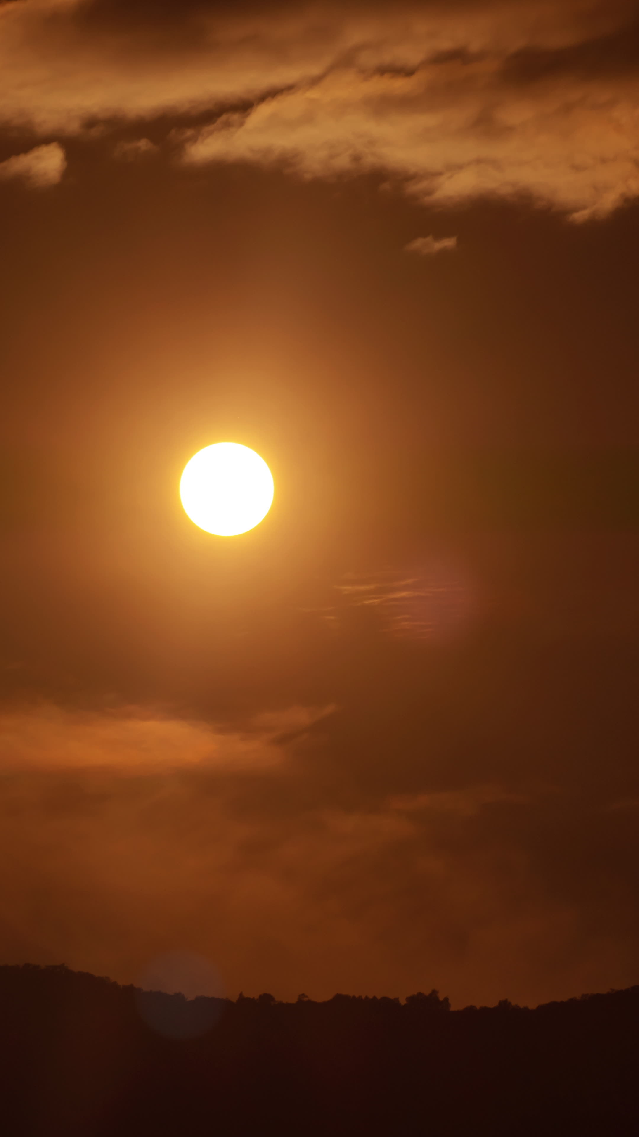 Vertical timelapse video of dramatic sunset with orange sky in a sunny