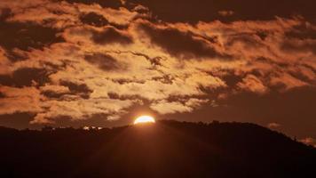 zonsopkomst in de oranje lucht 4k tijd vervallen video. geweldig landschap van lucht en silhouet van berg Aan de horizon. video