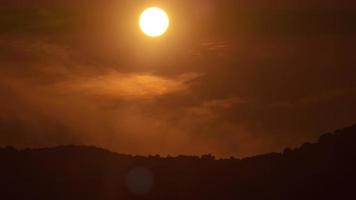Sonnenuntergang im orangefarbenen Himmel 4k Zeitraffervideo. fantastische himmelslandschaft und bergsilhouette am horizont. video