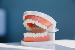 Stomatology concept, partial portrait of girl with strong white teeth looking at camera and smiling, fingers near face. Closeup of young woman at dentist's, studio, indoors photo