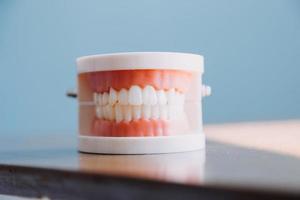 Stomatology concept, partial portrait of girl with strong white teeth looking at camera and smiling, fingers near face. Closeup of young woman at dentist's, studio, indoors photo