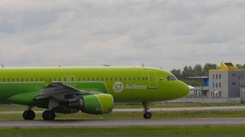 novosibirsk, federación rusa 15 de julio de 2022 - avión de s7 airlines acelerando en la pista antes del despegue en el aeropuerto de tolmachevo, vista lateral. concepto de turismo y aviación video