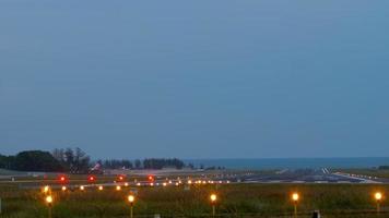 beleuchtung offen auf der landebahn des flughafens phuket am sonnenaufgangshimmel video