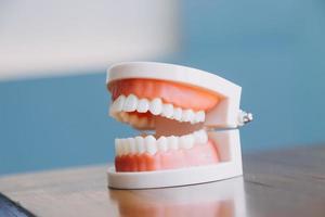 Stomatology concept, partial portrait of girl with strong white teeth looking at camera and smiling, fingers near face. Closeup of young woman at dentist's, studio, indoors photo