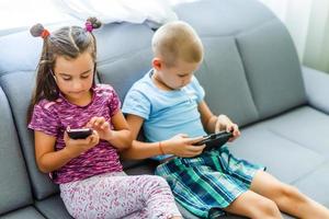 niños en edad preescolar jugando en el teléfono inteligente foto