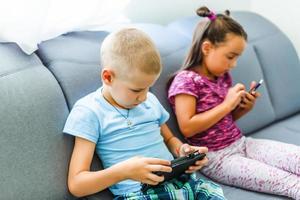 Cheerful children with smartphones in hands playing photo