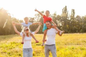 Young happy family with two children in the summer park photo