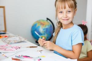 educación, creación y concepto escolar - niña estudiante sonriente dibujando y soñando despierta en la escuela foto