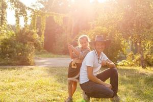 papá e hija vestidos al estilo vaquero se divierten en la granja foto