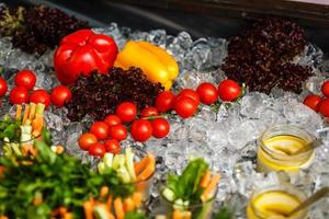 Small red cherry tomatoes spill out of a wicker basket on an old wooden table in rustic style, selective focus photo