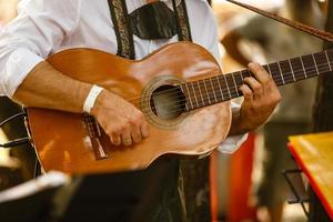 Close up of guitarist hand playing acoustic guitar photo