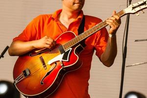 Close up of guitarist hand playing acoustic guitar photo