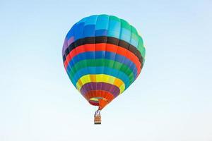 Hot air balloon over the field with blue sky photo