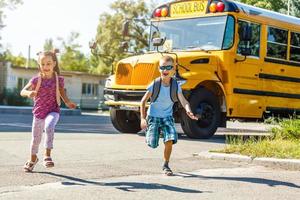 niños de primaria saliendo de la escuela para tomar el autobús escolar foto